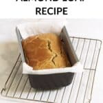 baked loaf of almond bread in parchment-lined pan.