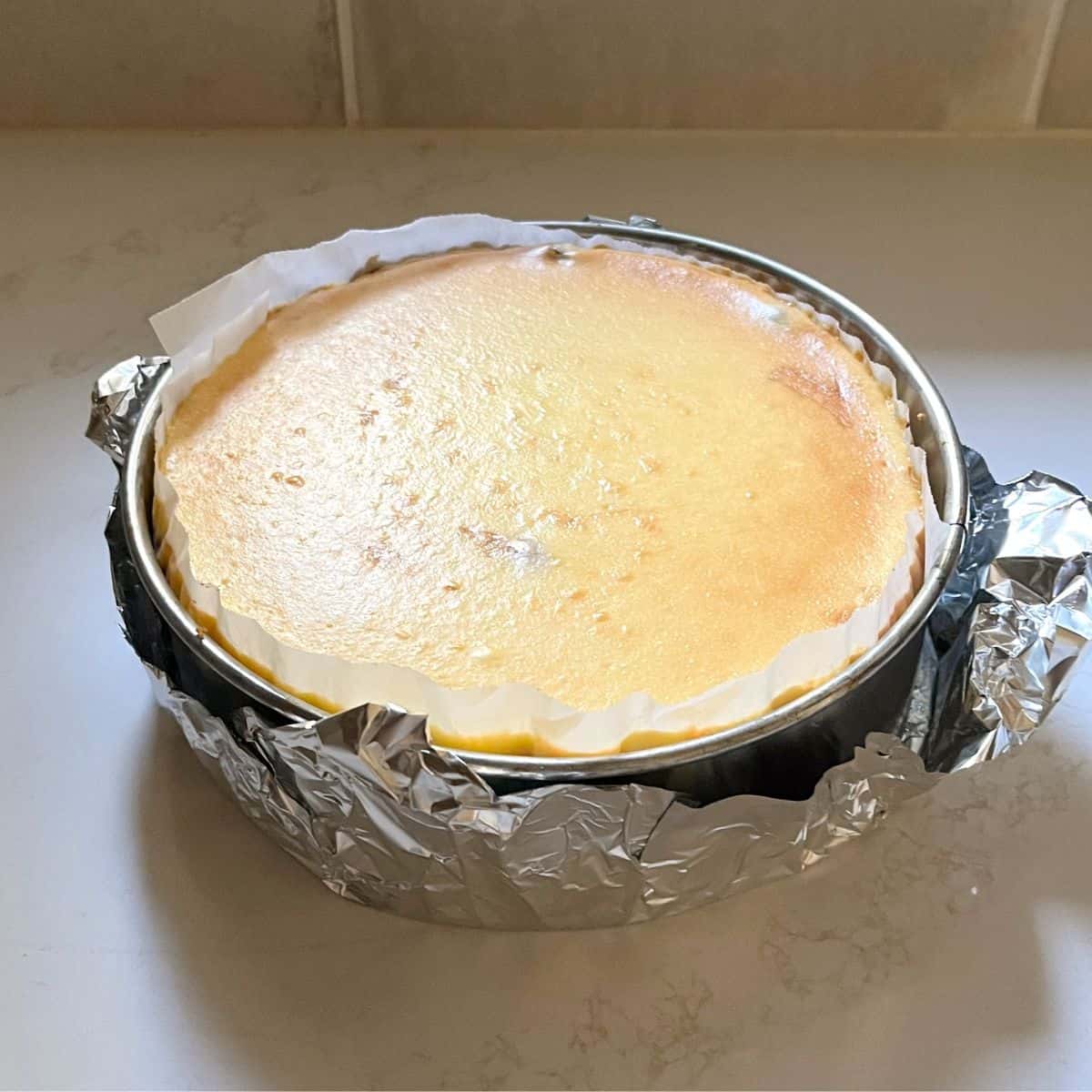 baked, uncracked cheesecake in pan.