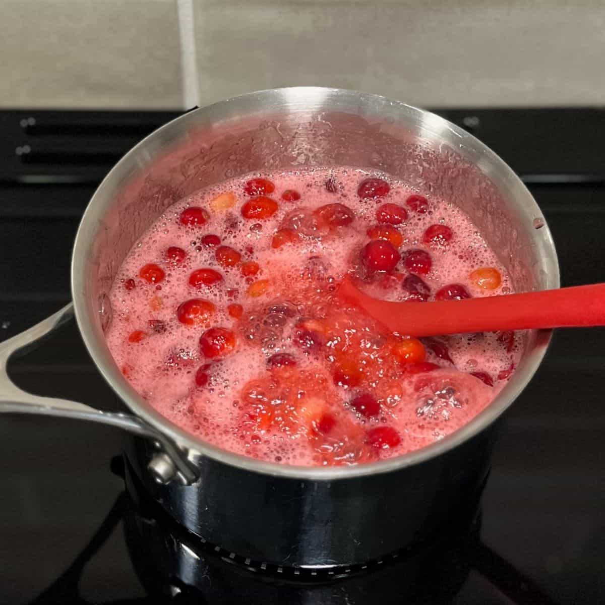 cranberry sauce boiling in a saucepan.
