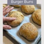 finger pressing soft, squishy gluten-free hamburger bun on tray.