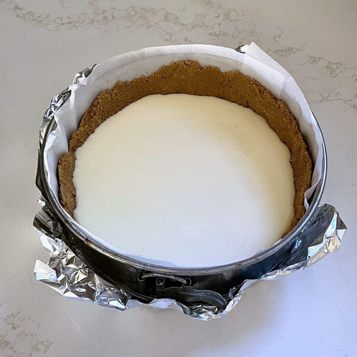 white, unbaked cream cheese mixture in crumb crust.