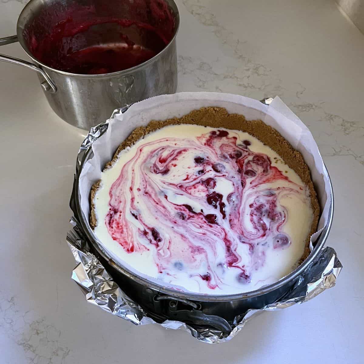 cranberry sauce swirled lightly throughout cream cheese filling in pan.