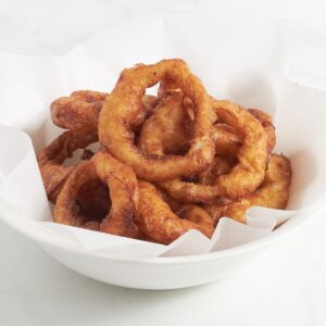 crispy, golden onion rings in white bowl.
