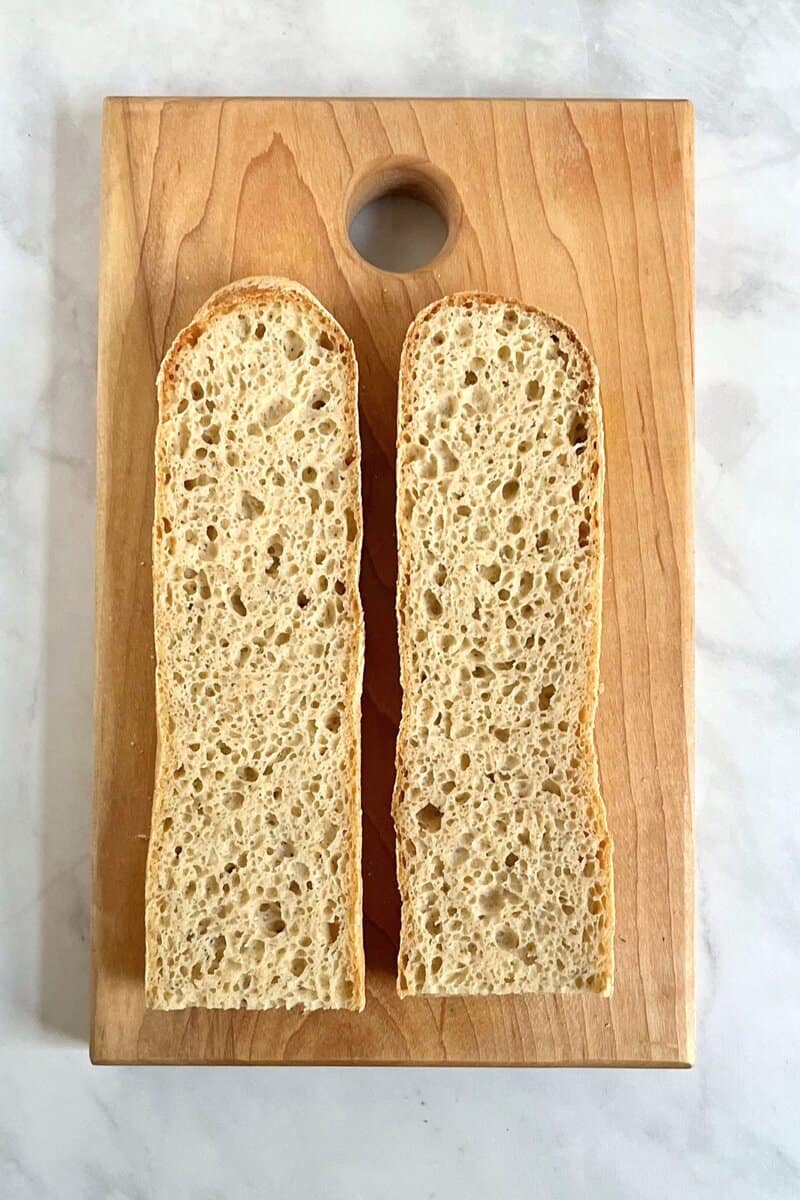 gluten-free baguette split open horizontally, revealing airy interior.