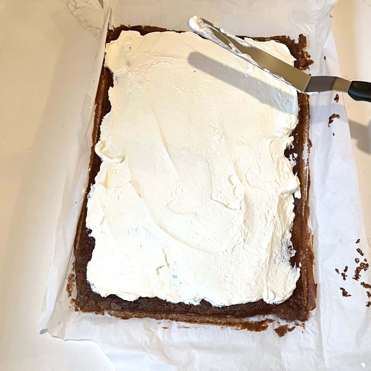 cream cheese frosting spread over thin chocolate cake.