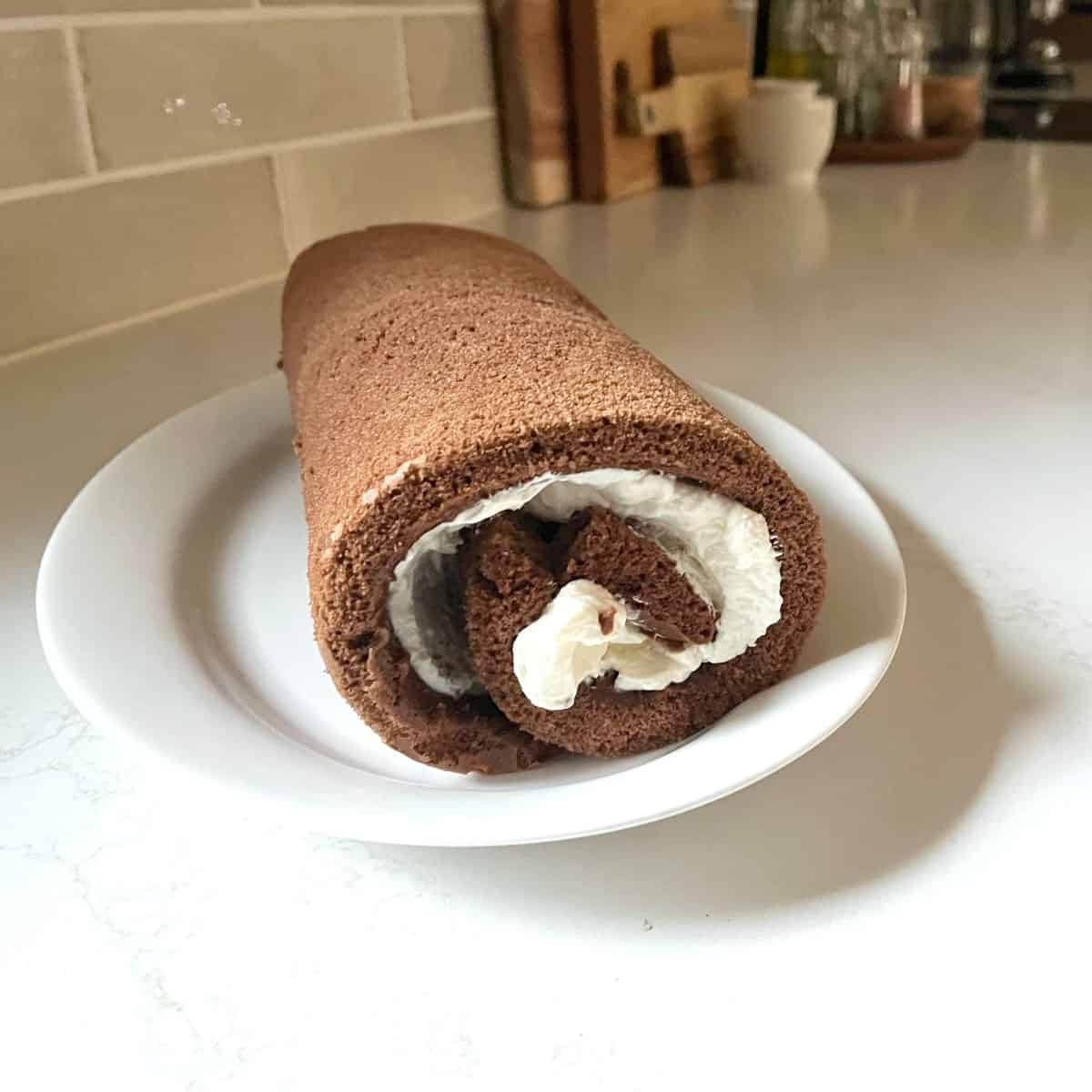 rolled up chocolate log with white filling between the layers.