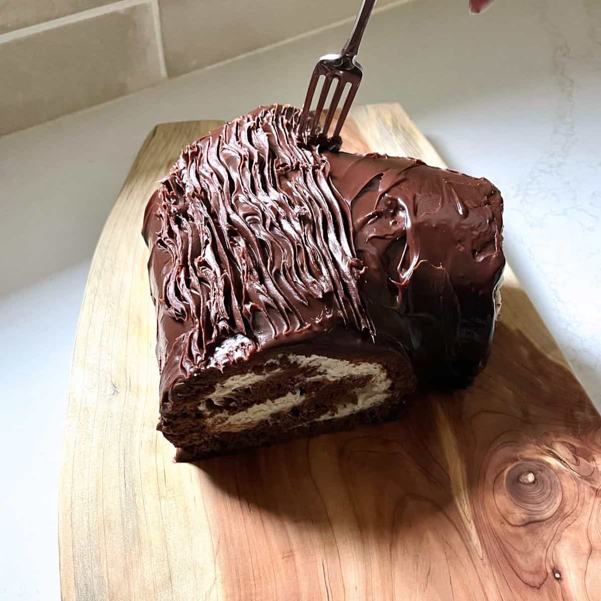 a fork is dragged through icing to make a bark texture.