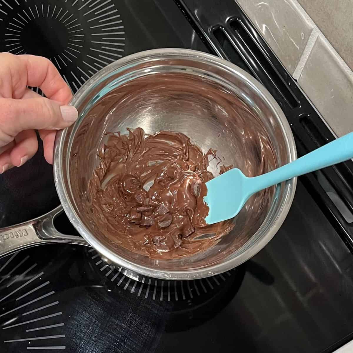 melting chocolate in bowl over saucepan on stovetop.
