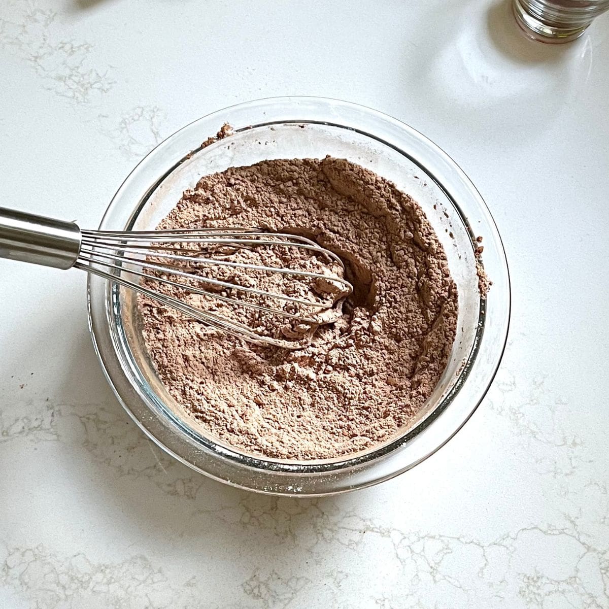 dry, brown flour-cocoa mixture whisked in glass bowl.