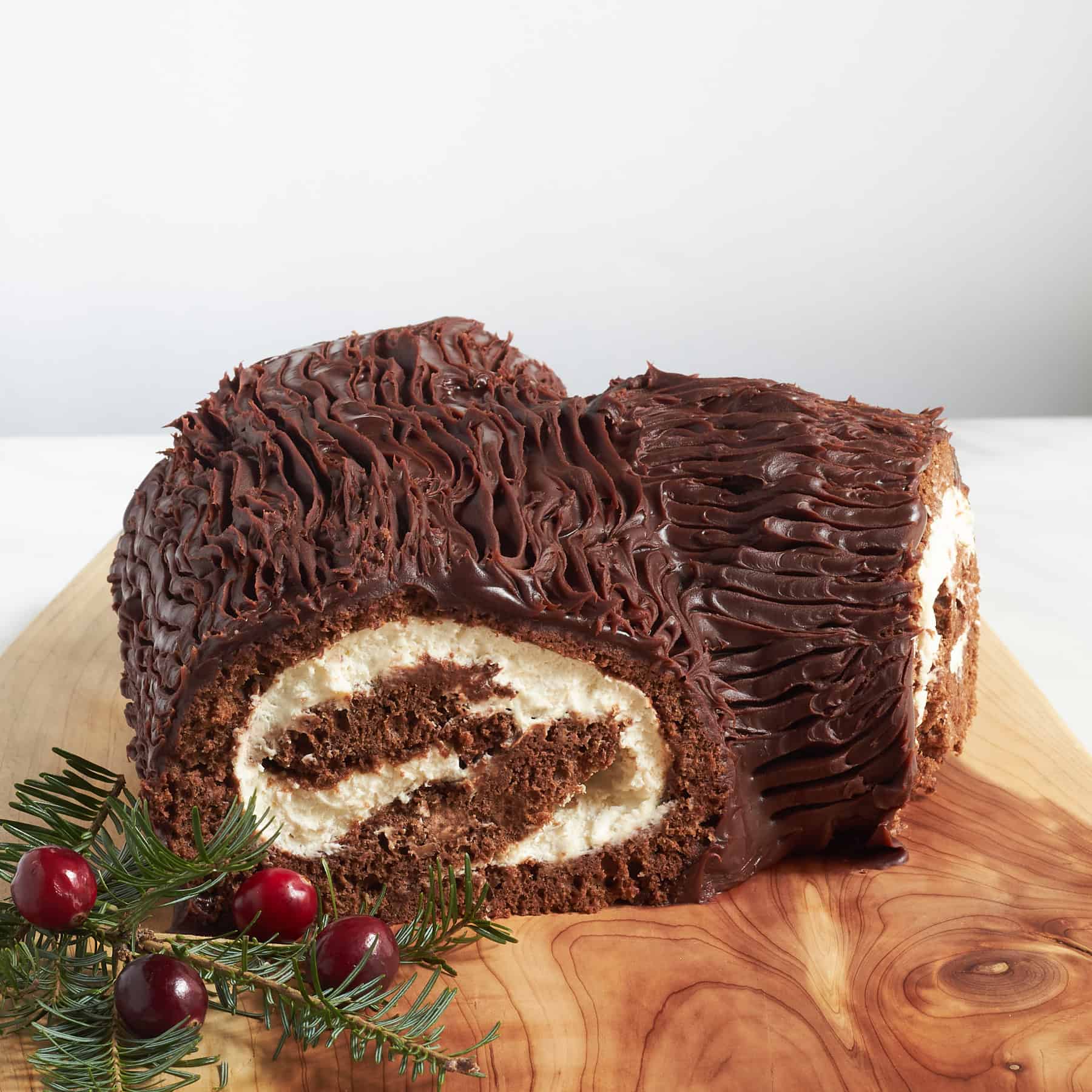 gluten-free chocolate log wrapped around whilte filling and frosted with chocolate ganache with bark texture.