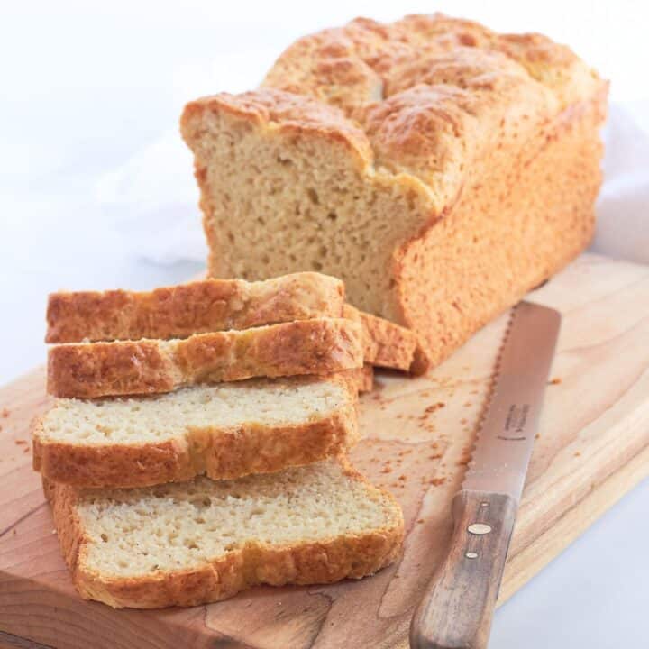 partially sliced loaf of golden gluten-free bread.