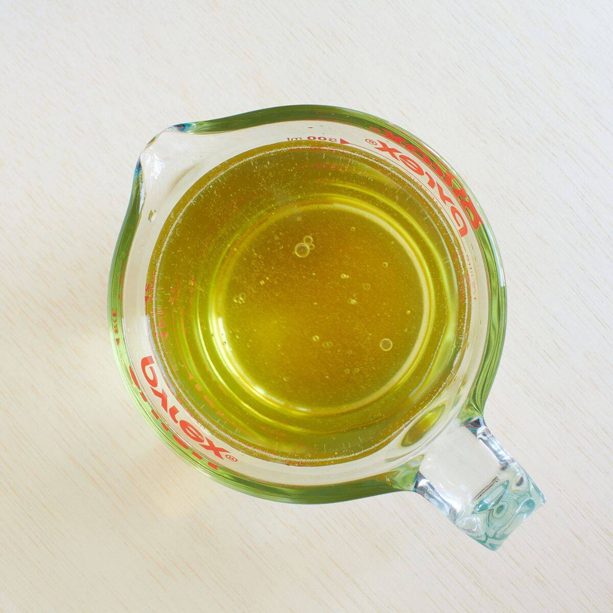 water, honey, oil, and vinegar in a Pyrex measuring cup.