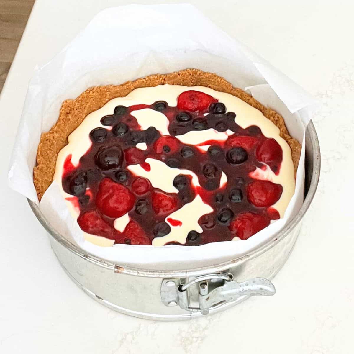 Mixed berry sauce added over soft cheesecake filling.