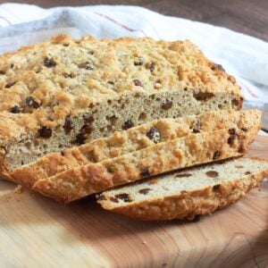 partially sliced, round loaf of gluten-free Irish soda bread with raisins.