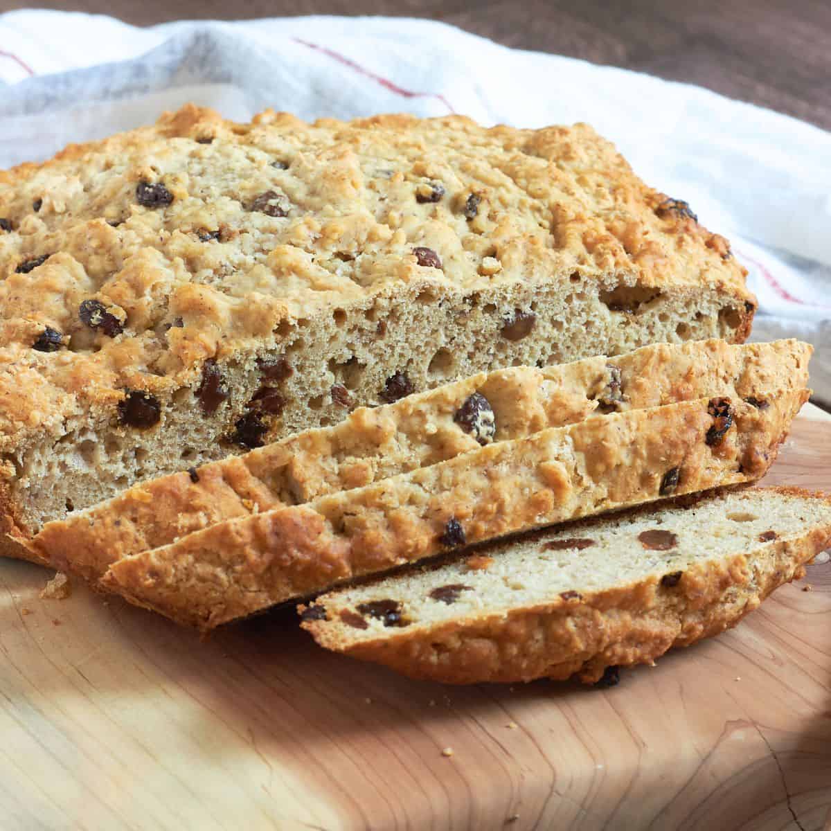 partially sliced, round loaf of gluten-free Irish soda bread with raisins.