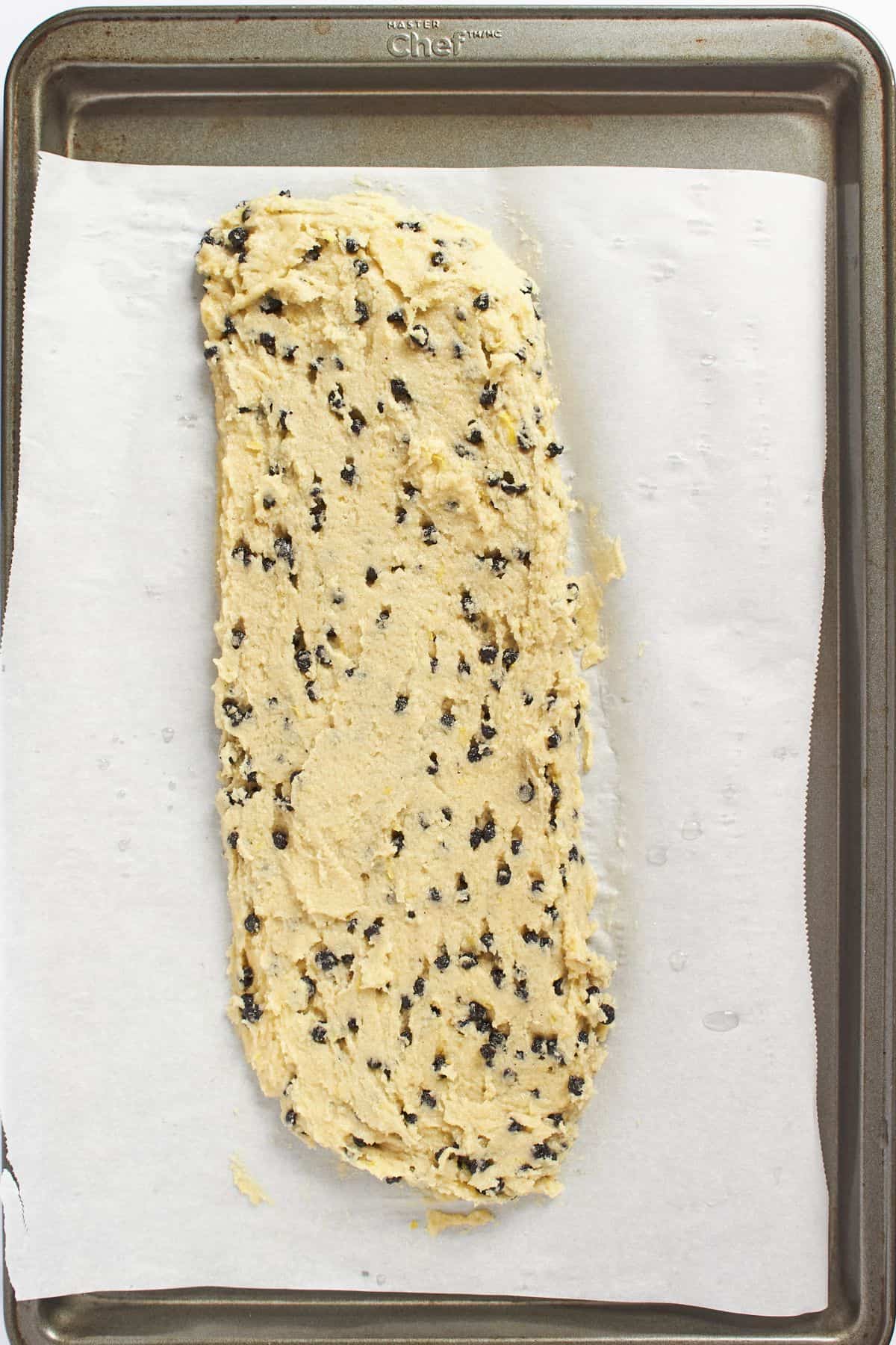 dough pressed out into oblong shape on parchment-lined tray.