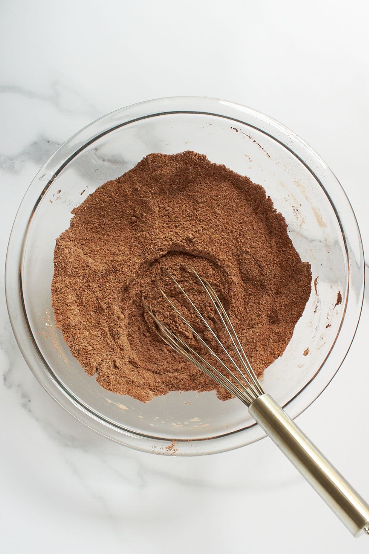 Whisk in brown, cocoa and flour mixture in glass bowl.