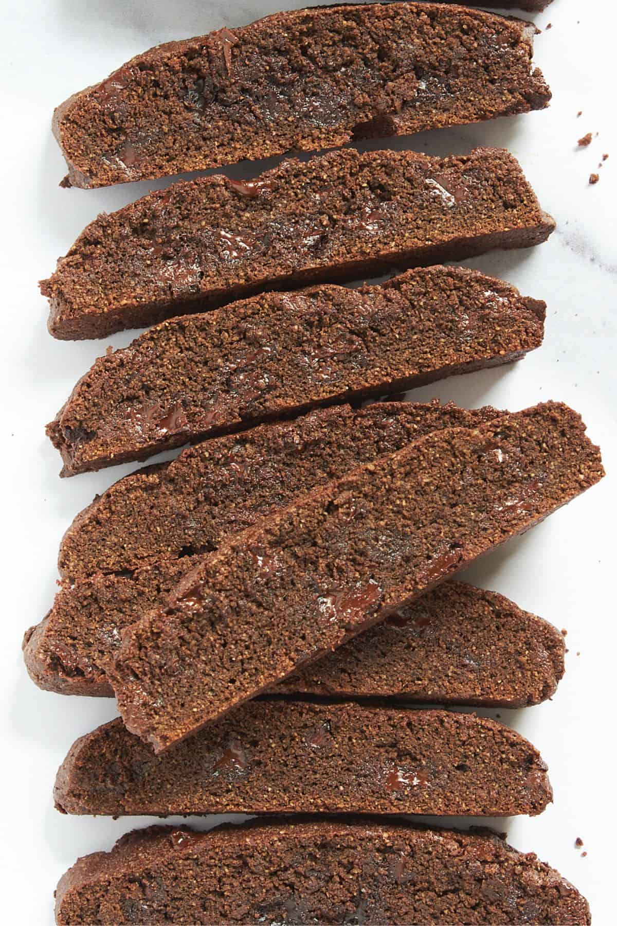 closeup of double chocolate biscotti lying on white marble.