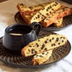 biscotti studded with dried blueberries arranged around a cup of tea.
