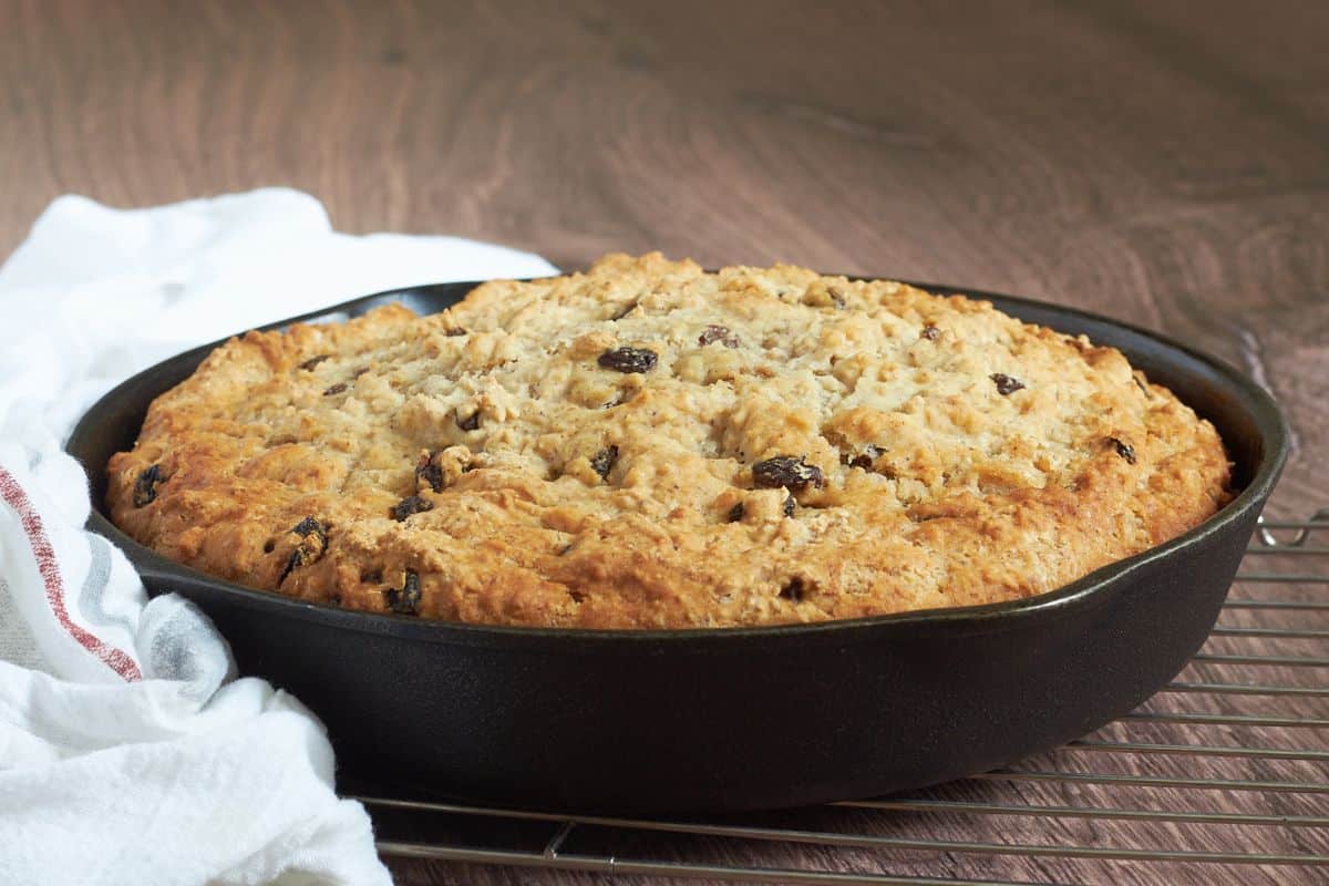 golden-crusted, gluten-free irish soda in cast-iron skillet on wire rack.