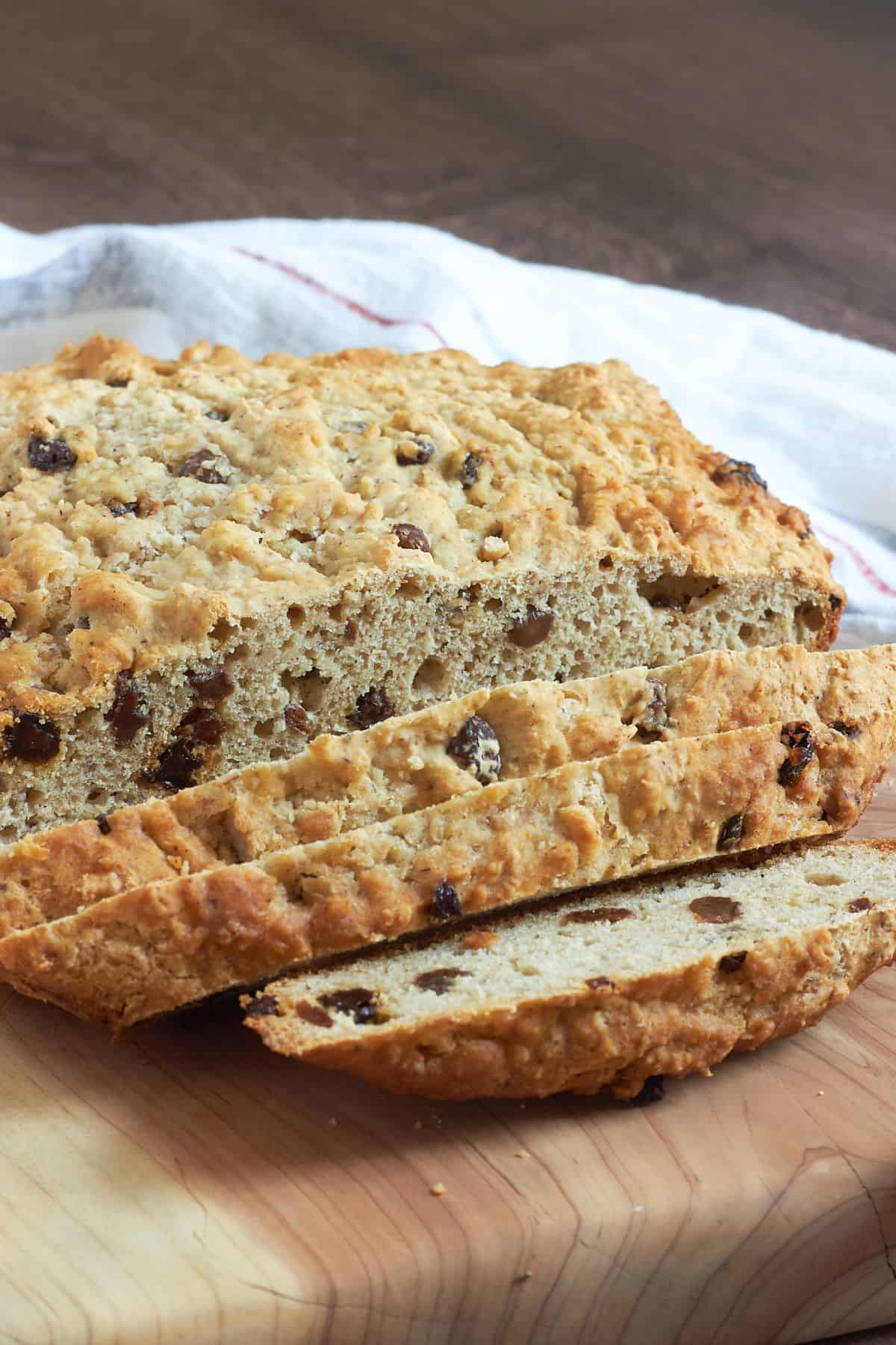 partially sliced gluten-free Irish soda bread on a wooden board.