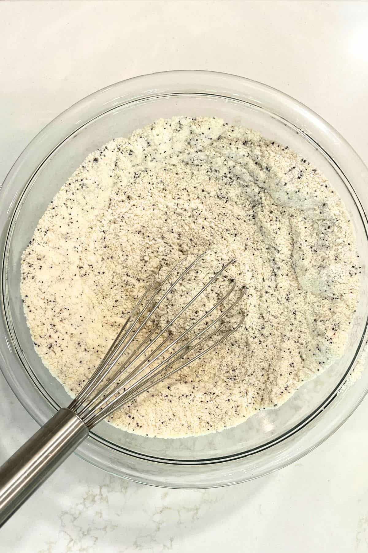 Whisk in dry flour mixture speckled by poppyseeds.