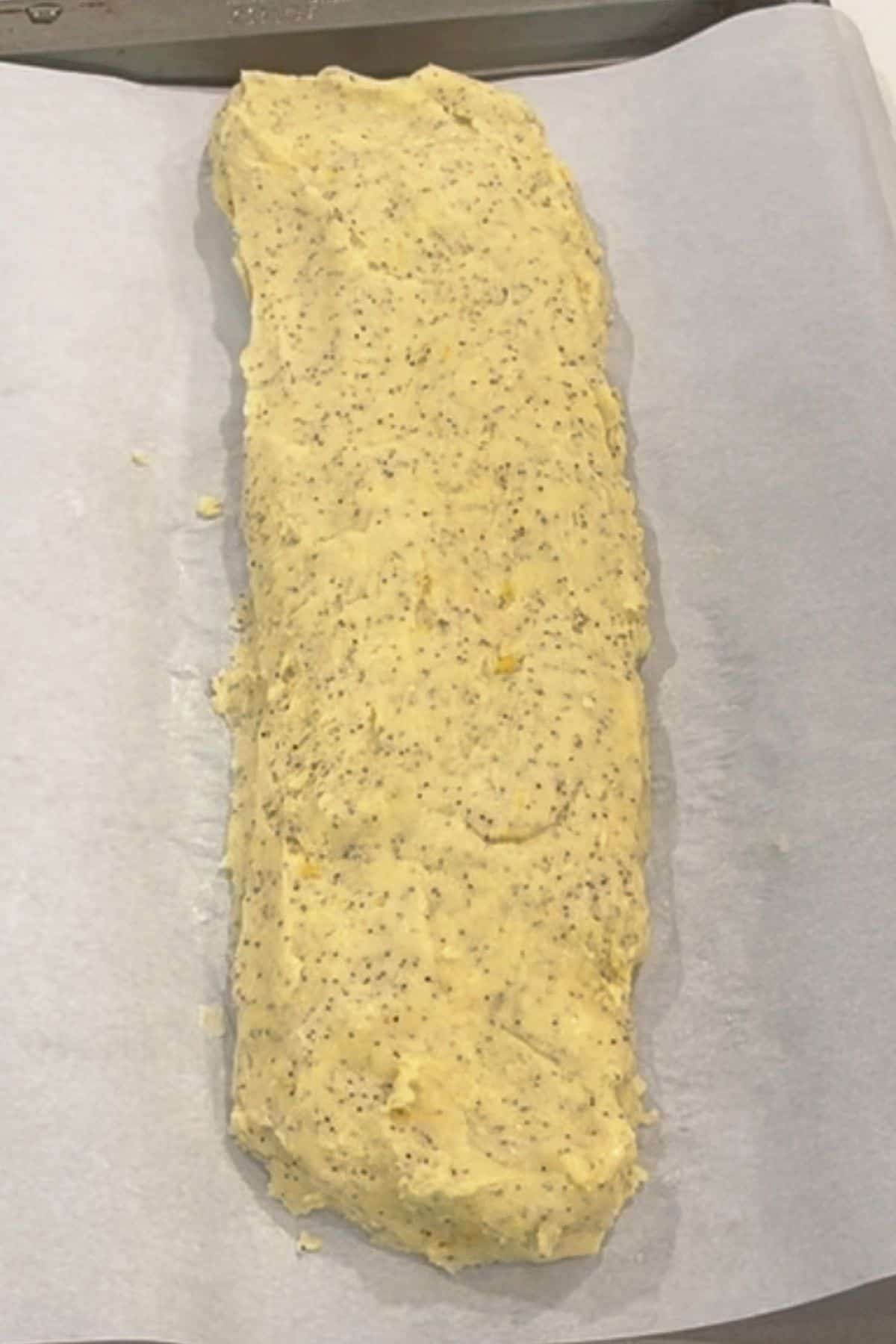unbaked flattish loaf of dough on parchment-lined baking sheet.