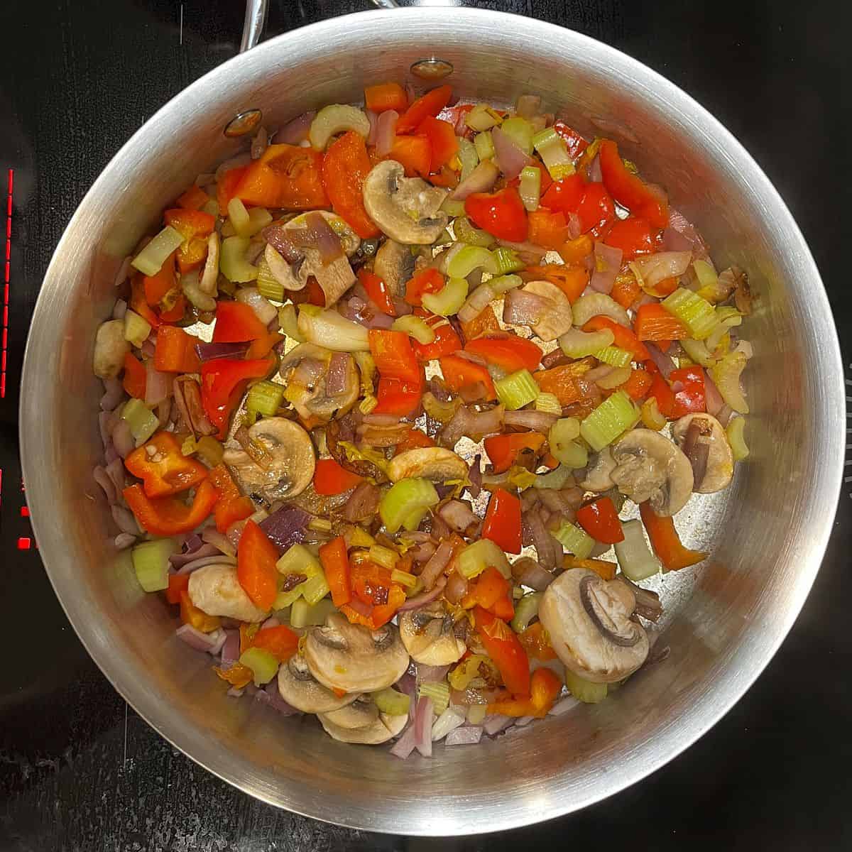 chopped vegetables frying in a skillet.