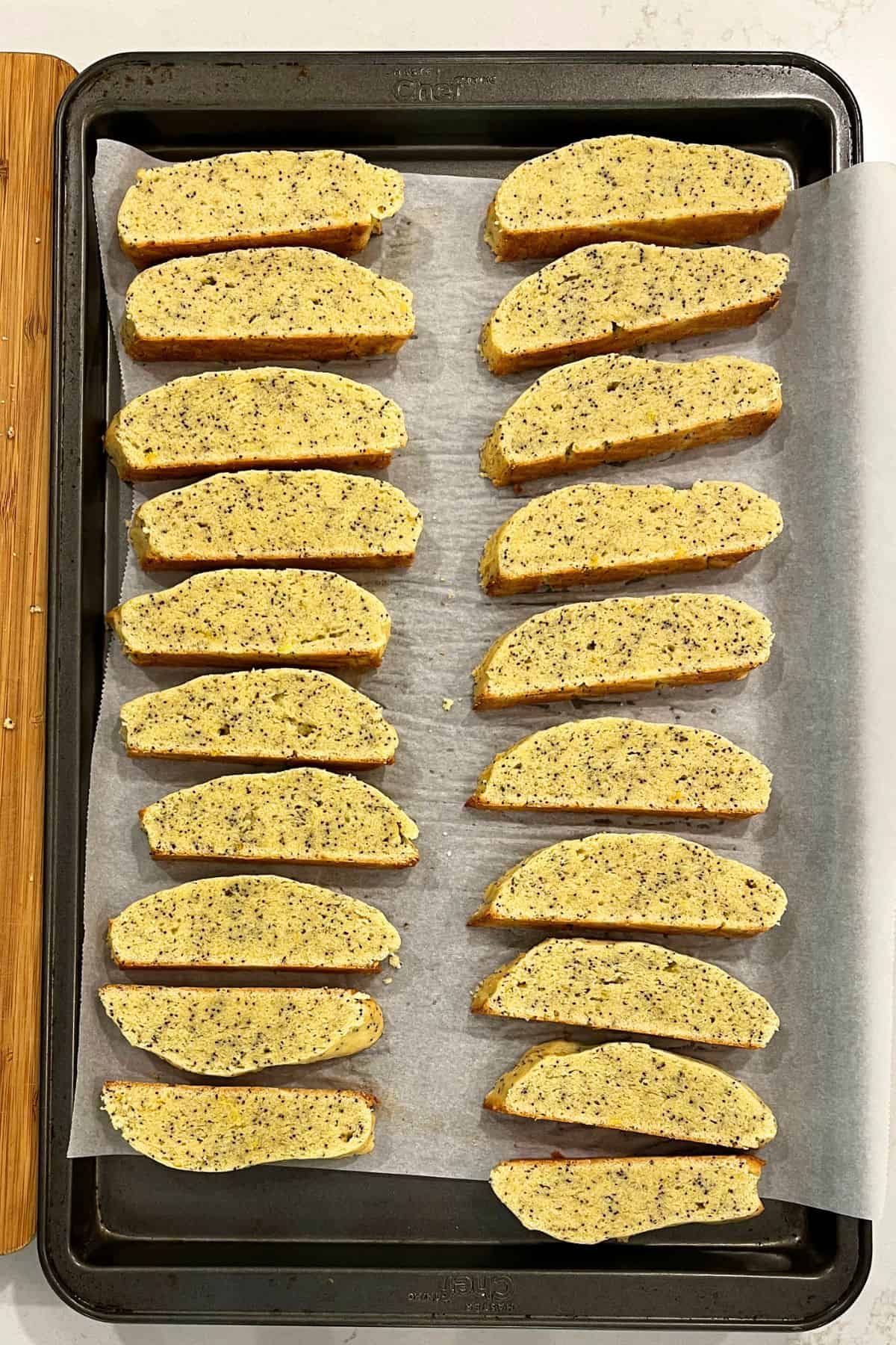 sliced biscotti layed out on parchment-lined baking sheet.
