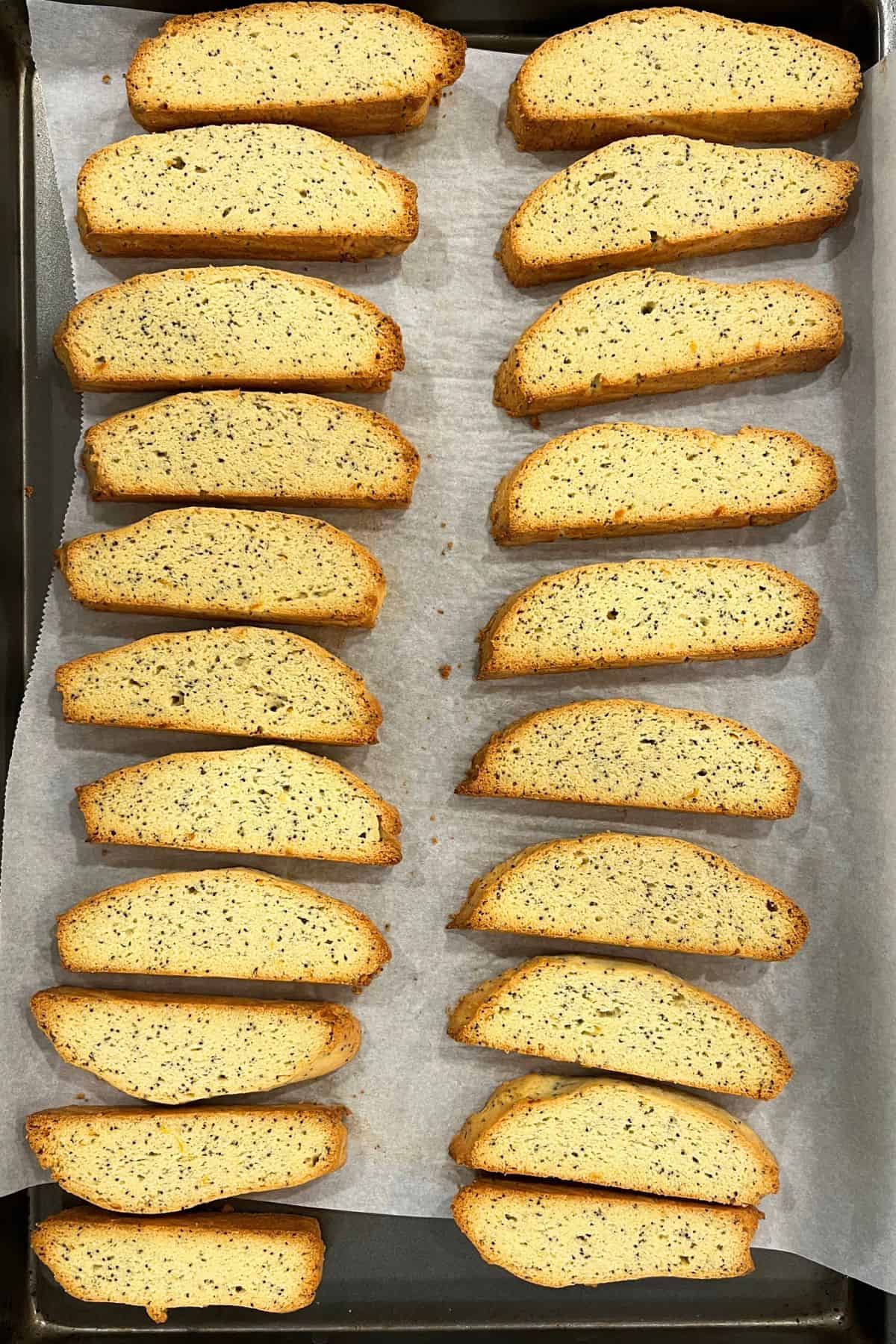 baked biscotti with golden edges on parchment-lined baking sheet.