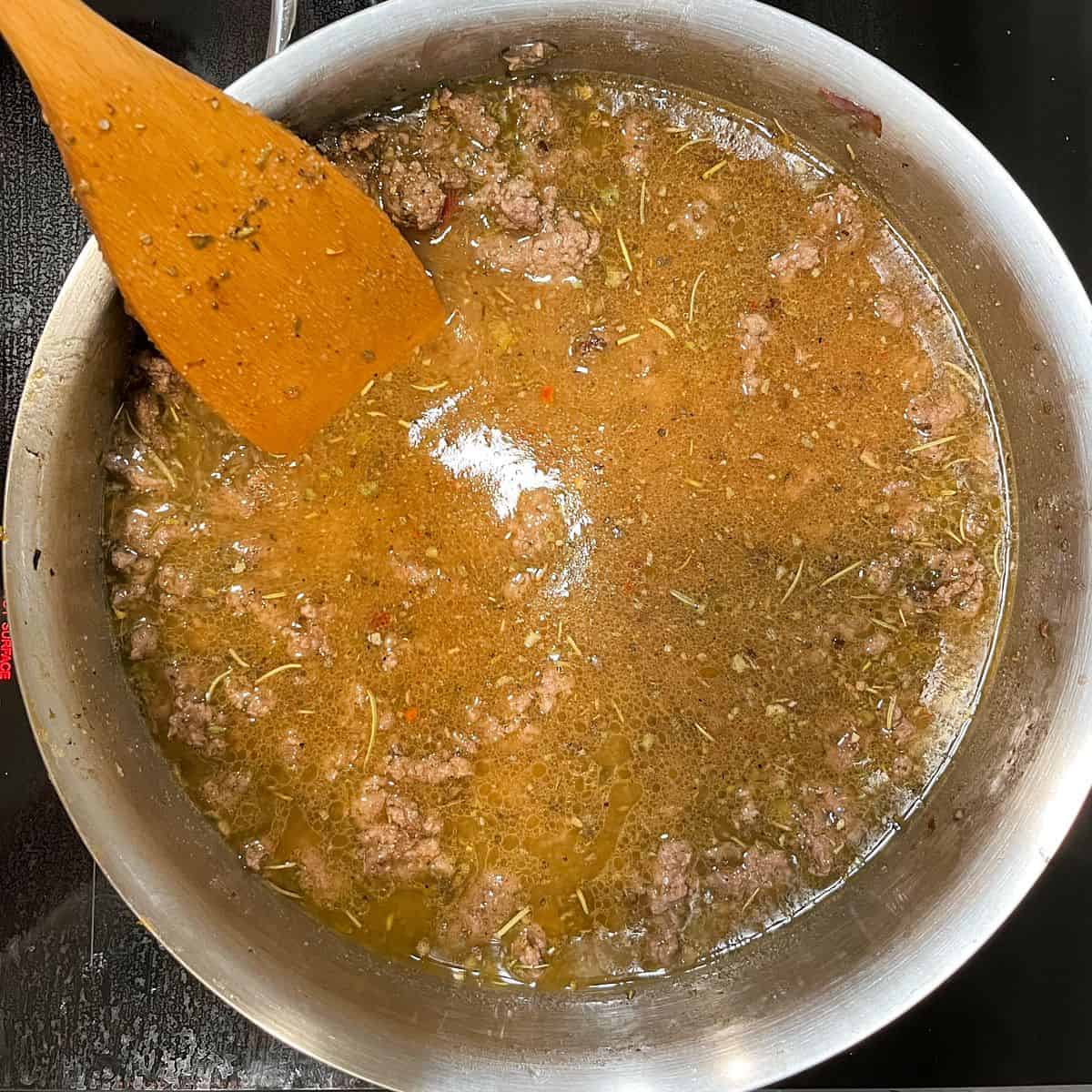 cooked ground beef with sauce in pan.