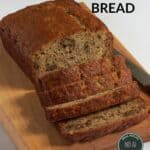 loaf of sliced gluten-free banana bread on wooden board.
